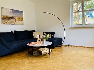 Die Ferienwohnung Krist überzeugt durch ein großes Wohnzimmer mit moderner Eckcouch, TV und schickem Couchtisch. 