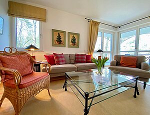 Ein In der Ferienwohnung 5 der Villa Seepark: Wohnzimmer im Landhausflair: gemütliche Couchecke mit schickem Glastisch