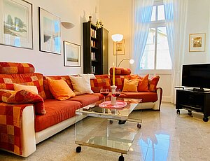 Willkommen in der stylischen Ferienwohnung 8 der Villa Caprivi, die gemütliche Sitzecke besteht aus einer großen Couch mit vielen Kissen, einem Glastisch und der TV- Kommode. Edle Materialien und hoher Komfort dazu Seeblick!