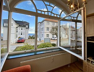 Ferienwohnung in Bansin mit Meerblick: Großes zweiflügeliges Fenster, das den Blick durch Nachbarvillen auf die Ostsee freigibt. Die erhöhte Lage der Villa Frieda ermöglicht einen Blick aus allen Fenstern sowie vom Balkon auf die Ostsee."