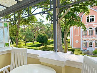 Den Urlaub in der Ferienwohnung 10 der Villa Caprivi auf dem überdachten Balkon mit Möbeln genießen.