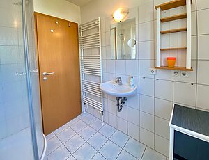 Badezimmer mit Dusche und Fenster in der Ferienwohnung Lindenweg 8b