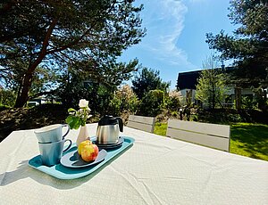 Urlaub in Karlshagen|Genießen Sie Ihre Mahlzeiten auf der sonnigen Terrasse mit schönem Blick in den Kiefernwald