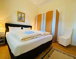 Elegantes Schlafzimmer der Ferienwohnung 3 Villa Caprivi mit großem Doppelbett und passendem Kleiderschrank.